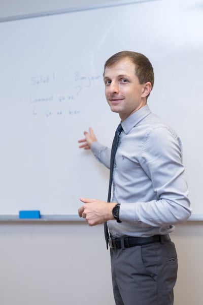a French teacher in front of a whiteboard